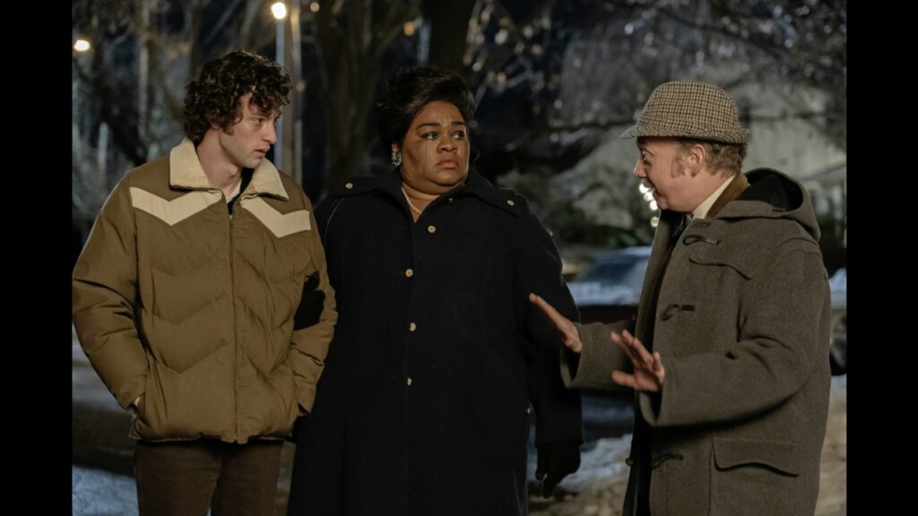 Szenenbild aus THE HOLDOVERS. Paul Giamatti spricht zu Dominic Sessa und Da’Vine Joy Randolph. Es ist Abend und Winter.